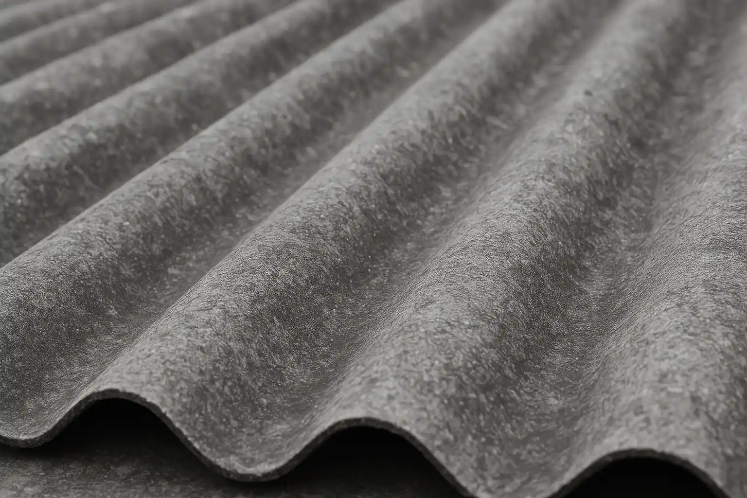 Toiture en fibro-ciment ondulé gris – gros plan des plaques, texture minérale, pose conforme DTU 40.37, visée informative sur entretien/désamiantage
